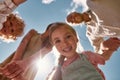 Portrait of adorable little girl holding parents and brother hands while looking down at camera with the blue sky above Royalty Free Stock Photo