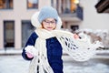 Portrait of adorable little girl outdoors on cold winter day. Cute preschool child in warm clothes, with knitted hat and