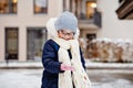 Portrait of adorable little girl outdoors on cold winter day. Cute preschool child in warm clothes, with knitted hat and