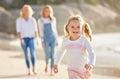 Portrait of an adorable little girl running and smiling on the beach during summer. Cute little girl having fun outdoors Royalty Free Stock Photo