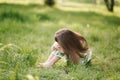 Portrait of adorable little girl sits barefoot on the grass in the park. Happy kid on the fresh air Royalty Free Stock Photo