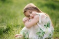 Portrait of adorable little girl sits barefoot on the grass in the park. Happy kid on the fresh air Royalty Free Stock Photo