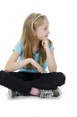 Portrait of a adorable little girl sitting on floor looking on copy space. Isolated on white background Royalty Free Stock Photo