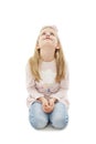 Portrait of a adorable little girl sitting on the knees, looking looking up on copy space Royalty Free Stock Photo