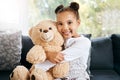 Portrait of an adorable little hispanic girl holding a teddy bear at home. Cute mixed race girl playing with her toy Royalty Free Stock Photo