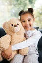 Portrait of an adorable little hispanic girl holding a teddy bear at home. Cute mixed race girl playing with her toy Royalty Free Stock Photo