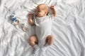 Portrait Of Adorable Newborn Child Napping On Bed With Rattle Toys Around Royalty Free Stock Photo