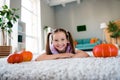 Portrait of adorable positive girl laying comfy carpet floor pumpkins free time calmness flat indoors Royalty Free Stock Photo