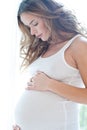 Portrait of adorable pregnant woman in white