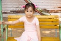 Portrait of adorable and pretty asian girl in pink ballet dress sitting lonely on swing in playground alone shows sadness of kid Royalty Free Stock Photo