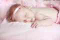 Portrait of adorable sleeping baby girl over pink, infant child. Royalty Free Stock Photo