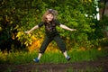 Portrait of adorable smiling girl jump in park at sunset. Child happy autumn come