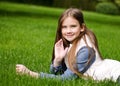 Portrait of adorable smiling little girl child preteen lying on grass in the park Royalty Free Stock Photo