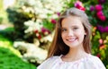 Portrait of adorable smiling little girl child in summer day. Happy preteen in the park