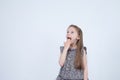 Portrait of adorable surprised astonished little girl isolated on a white. Girl child holding hands at the mouth surprised. Royalty Free Stock Photo