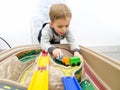 Portrait of adorable toddler boy playing with colorful plastic toy trains Royalty Free Stock Photo