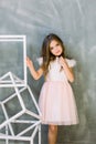 Portrait of an adorable toddler girl wearing fashion knitted clothes on the grey background Royalty Free Stock Photo