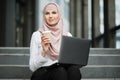 Portrait of muslim woman in hijab working on laptop outdoors Royalty Free Stock Photo