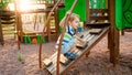 Portrait of adorable 3 years old boy climbing on ladder on the children palyground at park