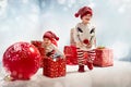 Portrait of adroable twin-elves among huge Christmas presents Royalty Free Stock Photo