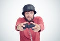 Portrait of adult bearded man in helmet holding joystick and playing videogames.