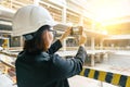 Portrait of adult female builder, engineer, architect, inspector, manager at construction site. Woman makes photo of building Royalty Free Stock Photo