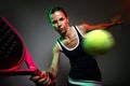 Adult fitness woman playing padel indoor. Isolated on black.