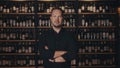 Portrait of an adult male restaurateur against the background of the wine shelves of an expensive restaurant. The