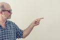 Portrait of an adult man gray-haired beard dark glasses shirt points his finger to the right