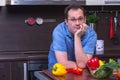 Portrait of adult sad man cooking in the kitchen