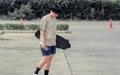 Portrait adult sportive Asian skater wearing hipster shirt with shorts, smiling with happiness, holding skateboard and standing