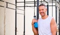 Portrait of adult sportive man smiling in an outdoor training gym.