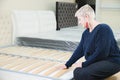 Portrait. Adult stylish woman, short-cut blonde, chooses a large orthopedic bed with a lifting mattress in a furniture Royalty Free Stock Photo