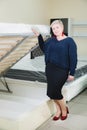 Portrait. Adult stylish woman, short-cut blonde, chooses a large orthopedic bed with a lifting mattress in a furniture Royalty Free Stock Photo