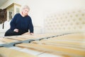 Portrait. Adult stylish woman, short-cut blonde, chooses a large orthopedic bed with a lifting mattress in a furniture Royalty Free Stock Photo