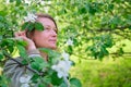 Portrait of an adult woman near a flowering apple tree in the spring garden Royalty Free Stock Photo