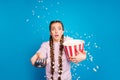 Portrait of afraid youngster girl with braids pigtails watch tv hold box with popcorn see horror series want switch Royalty Free Stock Photo