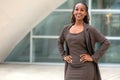 Modern portrait of African American female business person standing by office building, architecture firm, law, finance or other p Royalty Free Stock Photo