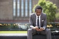 Portrait of African American Businessman listening to music with headphones outdoors