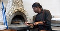 Portrait of african american chef man baking pizza in oven Royalty Free Stock Photo