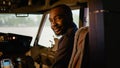 Portrait of african american copilot sitting in airplane cockpit Royalty Free Stock Photo