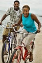 Portrait of african american couple riding bicycle on seashore