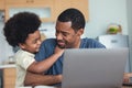 Portrait of African american cute little boy hugging of handsome dad working laptop computer while sitting at kitchen table at Royalty Free Stock Photo