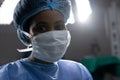 Portrait of african american female doctor wearing face mask in hospital operating room Royalty Free Stock Photo