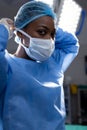 Portrait of african american female doctor wearing face mask in hospital operating room Royalty Free Stock Photo