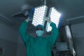 Portrait of african american female surgeon wearing surgical gown and face mask in operating theatre Royalty Free Stock Photo