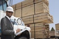 Portrait of African American male contractor writing notes while standing by logging truck Royalty Free Stock Photo