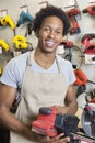 Portrait of an African American male store clerk holding electronic tool