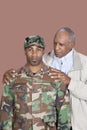 Portrait Of African American Male US Marine Corps Soldier With Father Over Brown Background