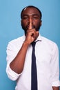 Portrait of african american man doing hush sign with index finger over lips Royalty Free Stock Photo